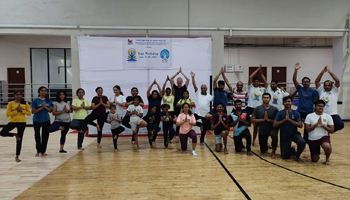 A group photo with yoga workshop participants standing on one-leg and posing with a namaste 