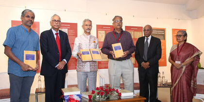 six people standing in a row, some of them displaying the newly released book in their hands